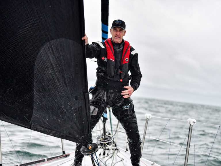 Man on sailboat wearing PFD