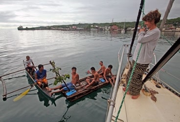 Carolyn shares a laugh with local boys who paddled out to see Wild Card in Maasin.