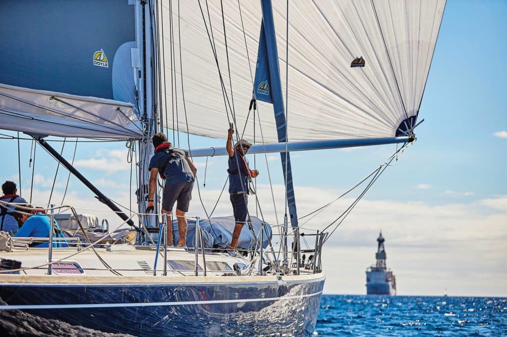 Sailors checking the rigging on a boat.