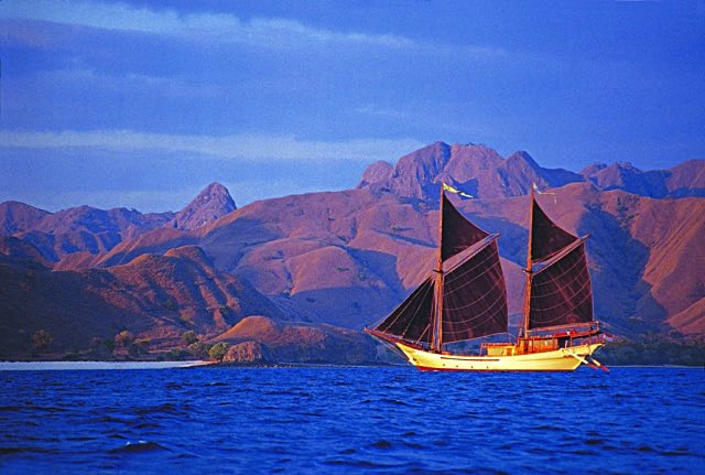 A phinsi, based on the design of a traditional cargo schooner native to Southeast Asia glides long the Lesser Sunda Islands, Indonesia.