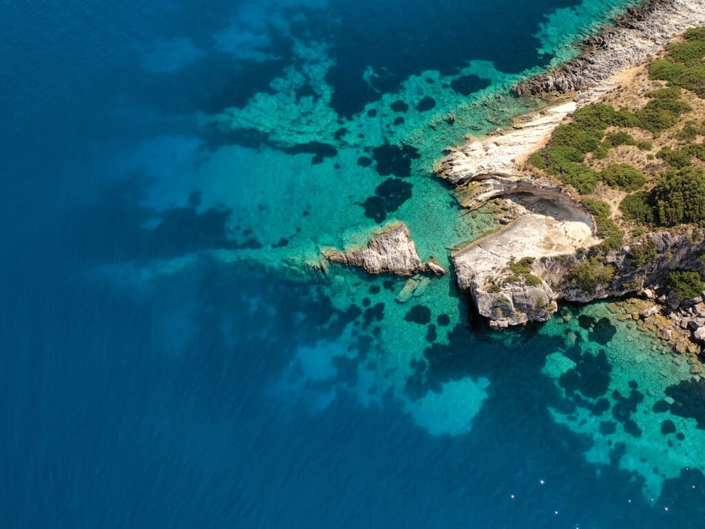 Top down aerial shot of rocks in the turquoise sea of Gidaki beach